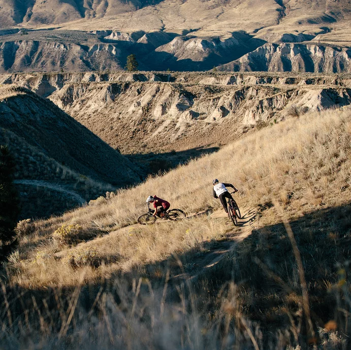 Mountain bikers ride electric bikes on a trail