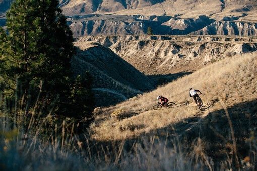 Mountain bikers ride electric bikes on a trail