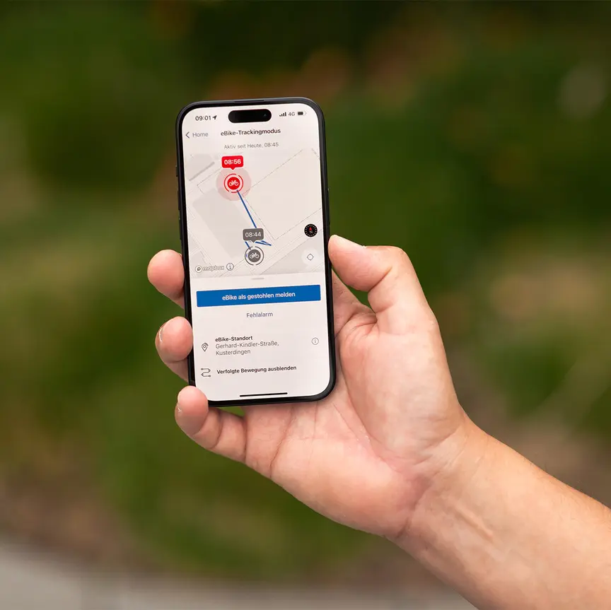 Auf einem in der Hand gehaltenen Smartphone ist der eBike-Trackingmodus der Flow App von Bosch eBike Systems zu sehen.