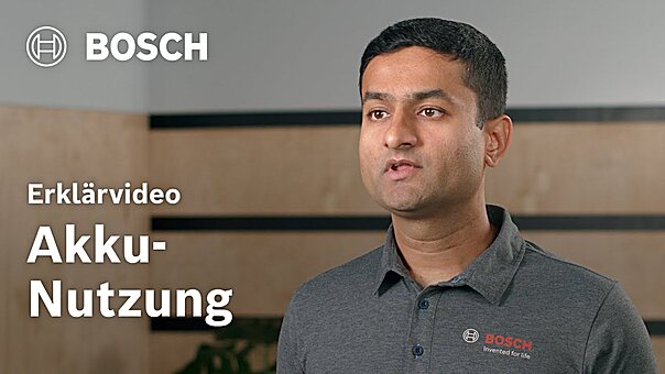 Ein Bosch Mitarbeiter vor einer Wand, welcher erklärende Bewegungen macht und in die Kamera redet. Links neben ihm.auf dem Bild die Aufschrift 'Erklärvideo Akku-Nutzung' und das Bosch Logo.