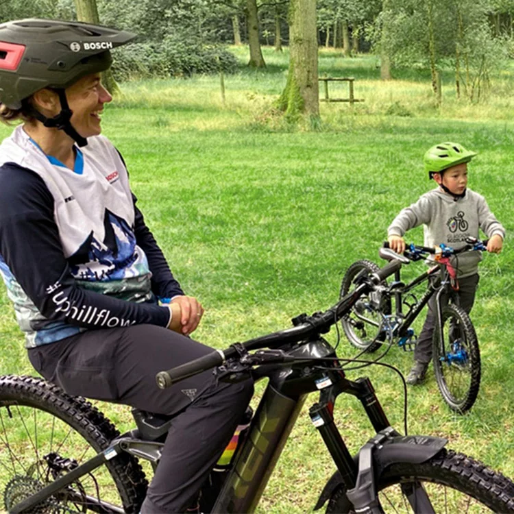 De cameraman zit in de Trek Fetch+2 eCargo Bike en filmt een jongen op zijn eBike. Een tweede eBike-rijder zit lachend op zijn fiets en kijkt naar hen.