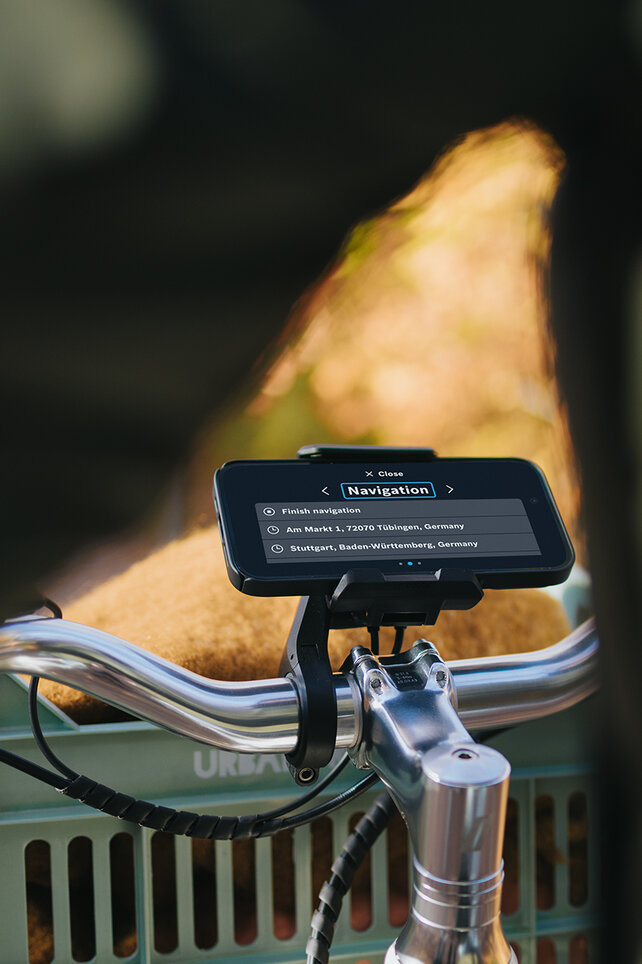 View of the handlebars of an eBike with SmartphoneGrip and the navigation setting open on the smartphone.