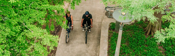 A man and a woman are riding Bosch-powered electric bicycles in Buffalo Bayou Park, near Houston, Texas.