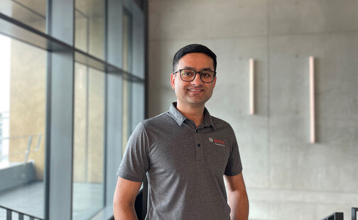 Vikram Godbole smiles at the camera while standing in a contemporary building.