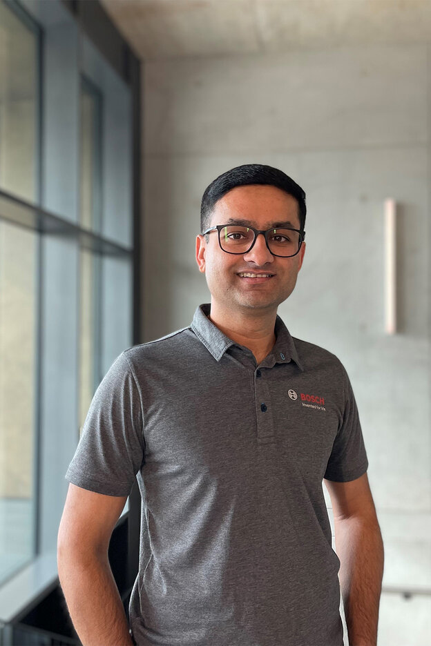 Vikram Godbole smiles at the camera while standing in a contemporary building.