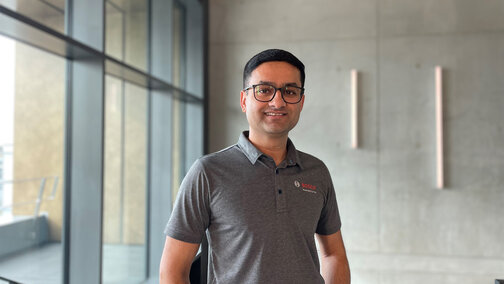 Vikram Godbole smiles at the camera while standing in a contemporary building.