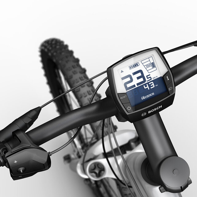 Una eBike plateada con manillar negro, aislada sobre un fondo blanco. En el manillar está montado el Intuvia Display del sistema Bosch eBike 2. El Display muestra en grande la velocidad en km/h, así como la autonomía en km. Además, el Display indica el estado de la batería y el modo de conducción.