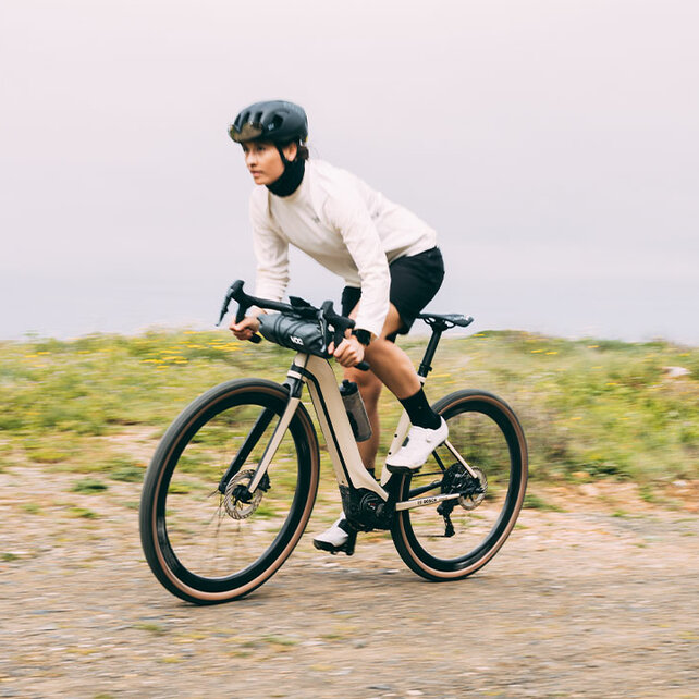 Twee eBikers rijden op hun eGravel-fietsen over een grindpad.