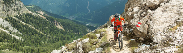 Ein eBiker fährt mit seinem eMountainbike einen schmalen Trail im Gebirge hinauf