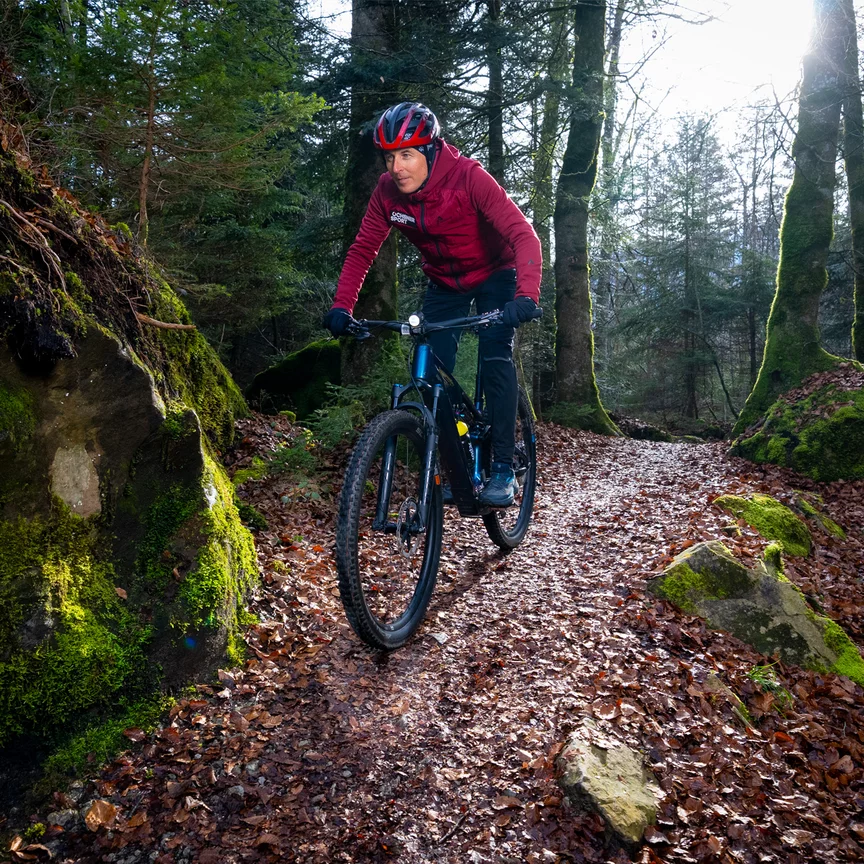 Viktor Röthlin conduit son VAE sur un étroit chemin forestier.