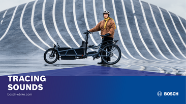 Sofie Birc stands next to her cargo bike on a street, with lines curving upwards behind her. Caption: 'Tracing Sounds bosch-ebike.com'.